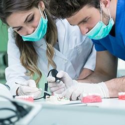 Two dental team members treating patient
