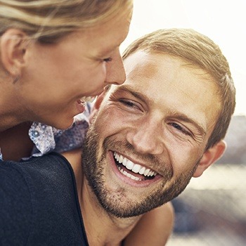 Young man and woman smiling together outdoors